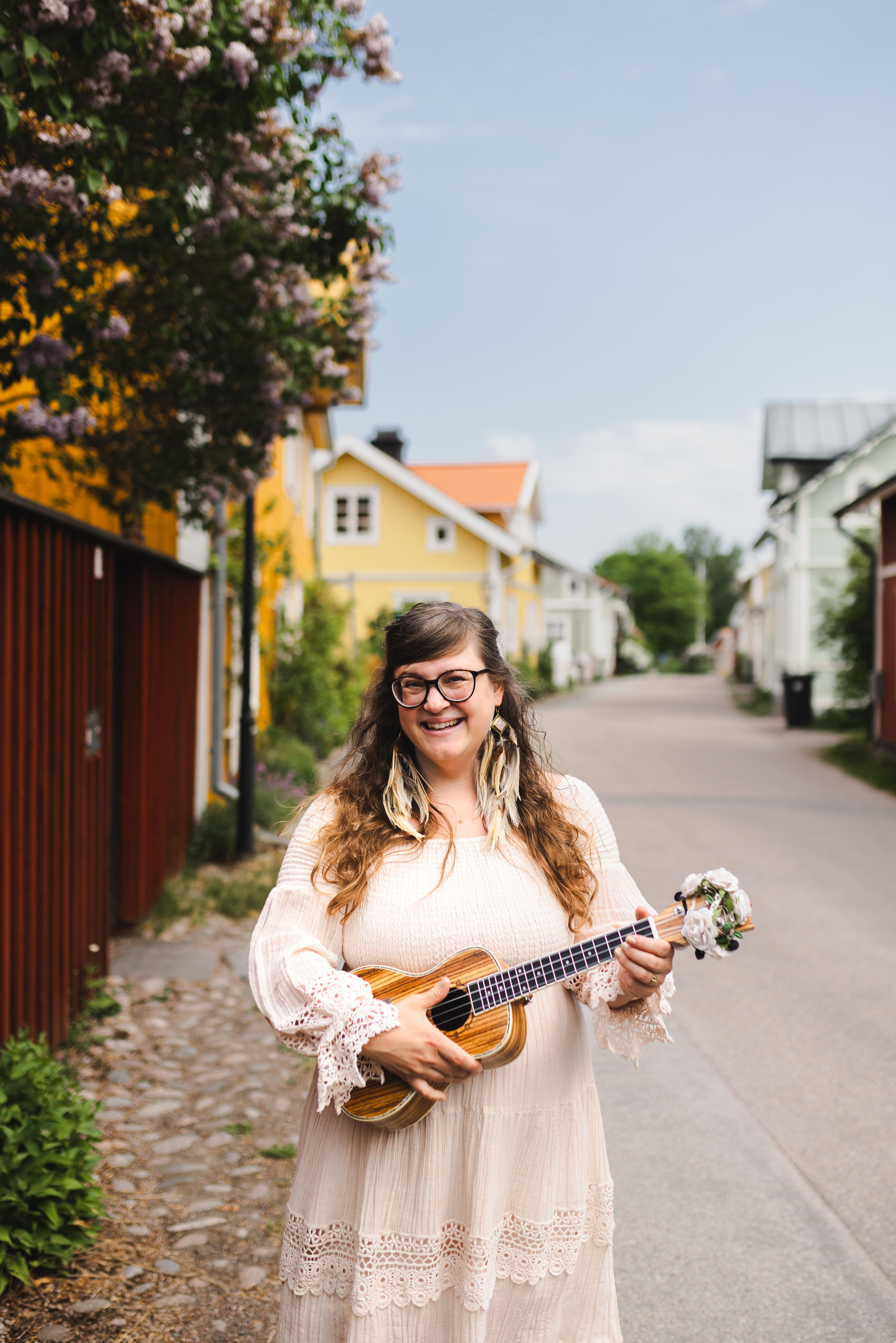 Emma D Haglund sitter vid forsen i Älvkalerby och spelar gitarr